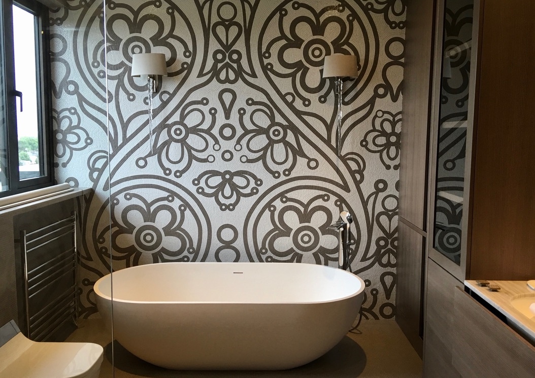 Ornate patterned mosaic feature wall behind a freestanding bath