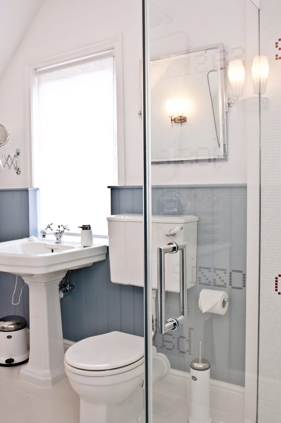Light blue and white period bathroom with pedestal sink and shower screen