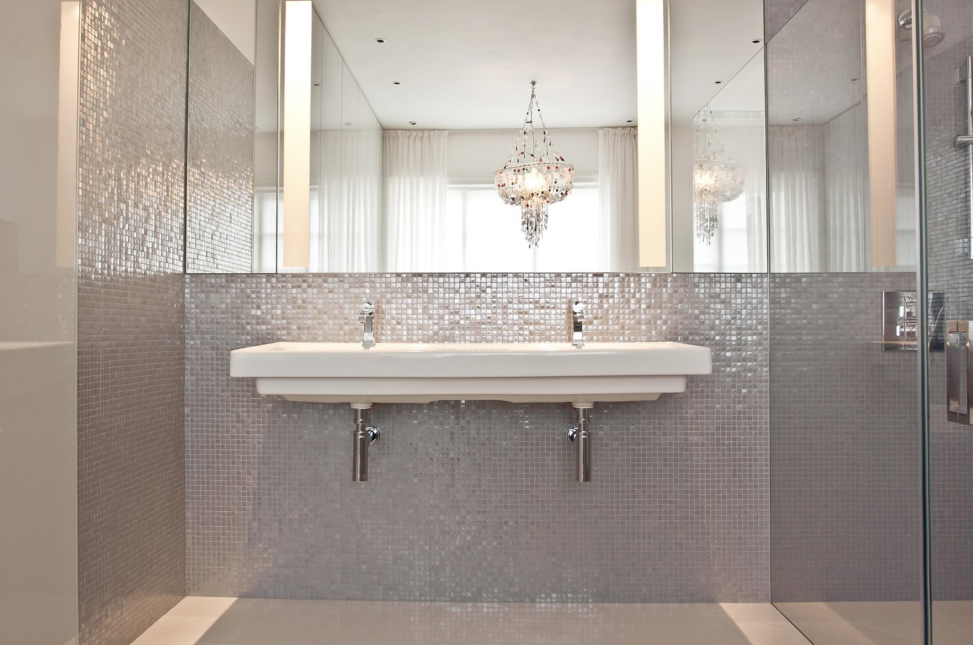 Double sink mosaic bathroom with statement chandelier