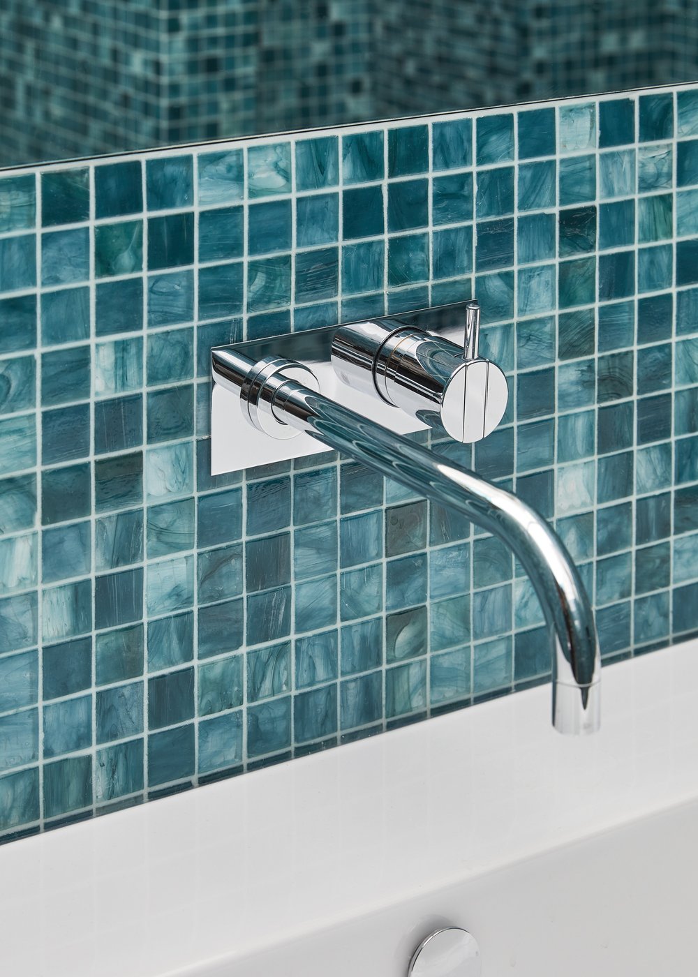 Teal glass mosaic tile with wall-mounted bath faucet