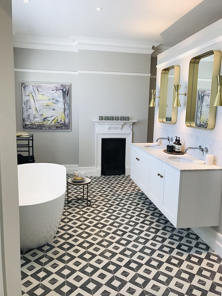 Black and white diamond patterned tile floor bathroom with gold mirrors