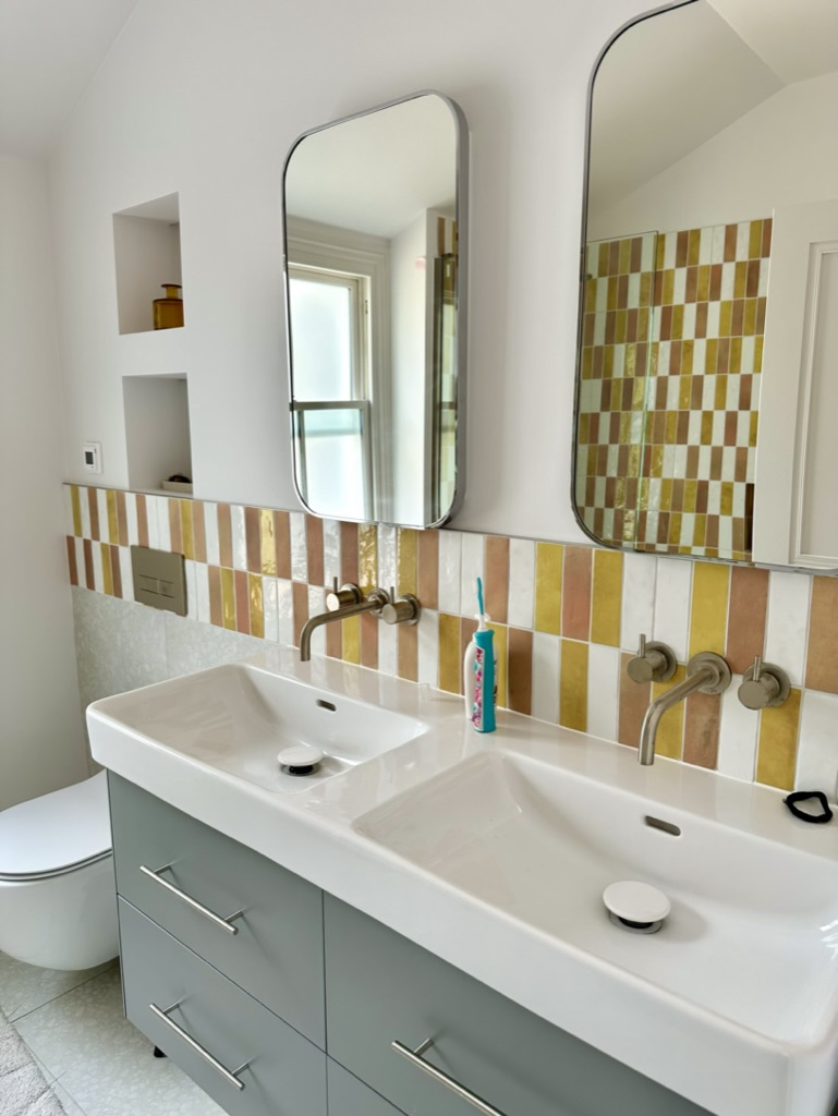 Yellow and orange checkerboard tile double vanity with mirrors